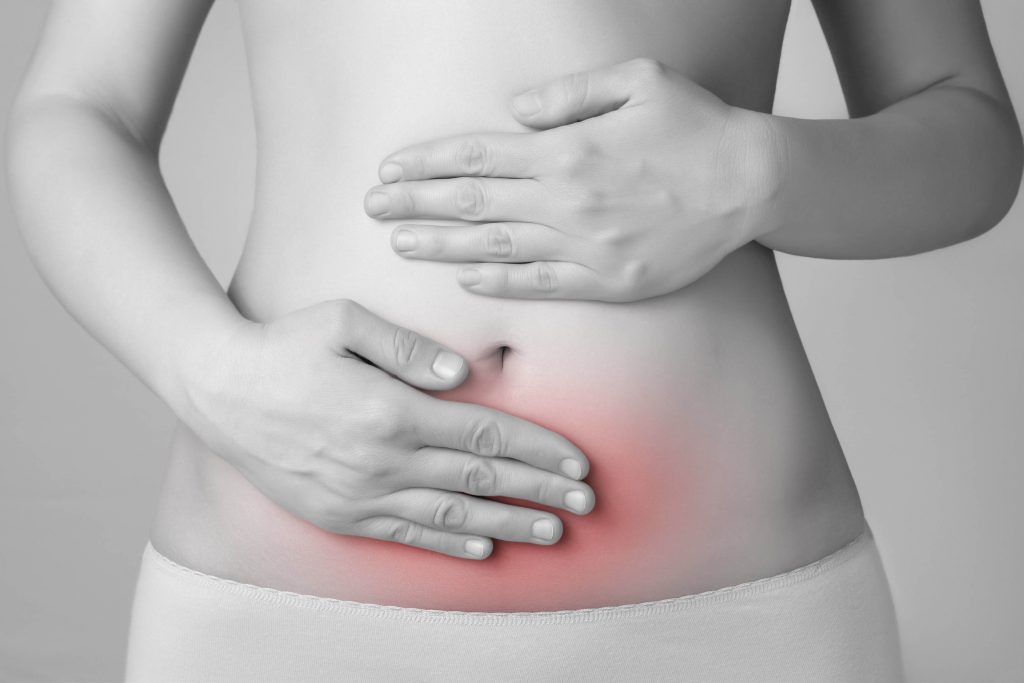 A young woman touching her painful abdomen