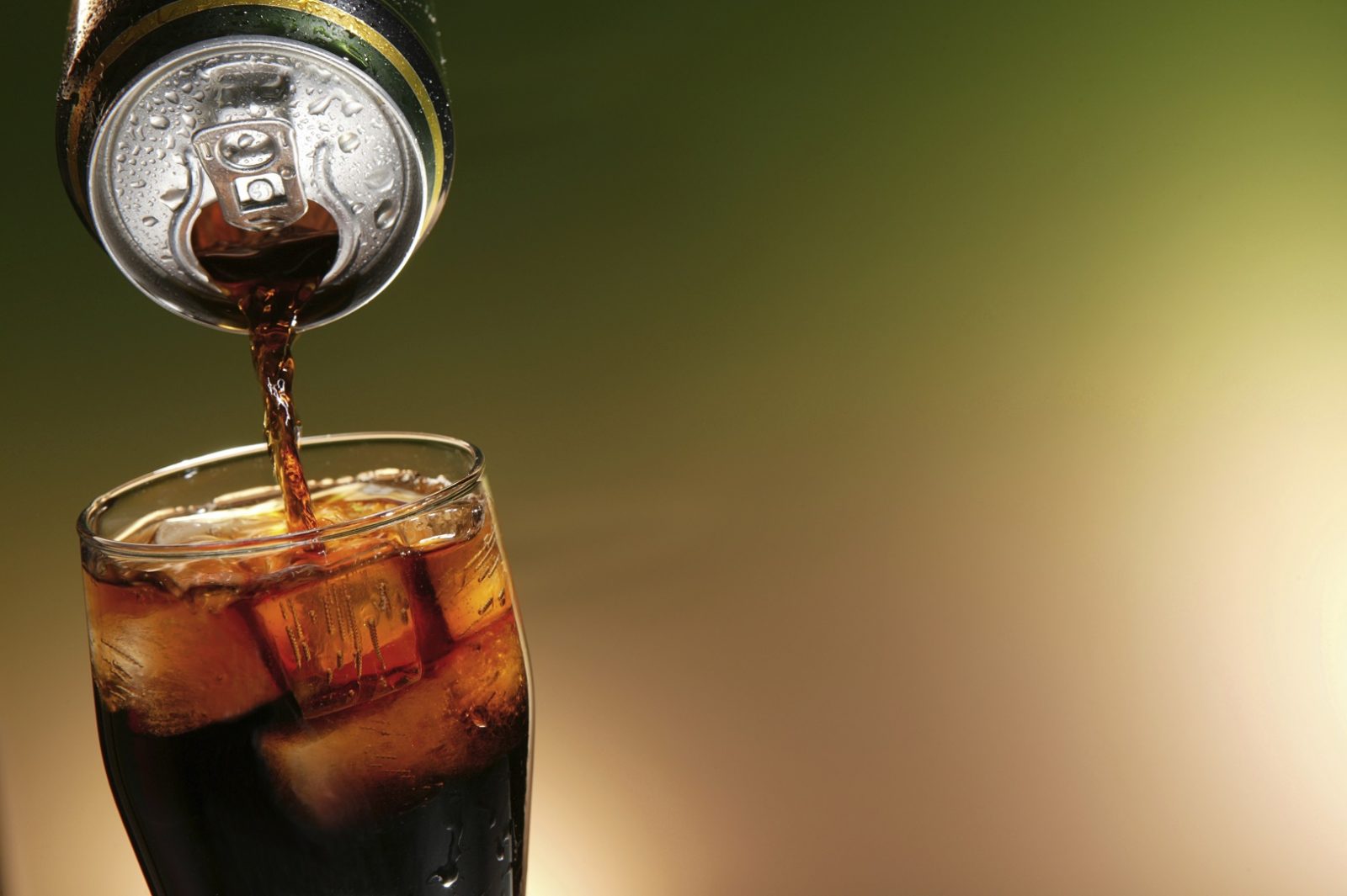 cola can pouring in a glass