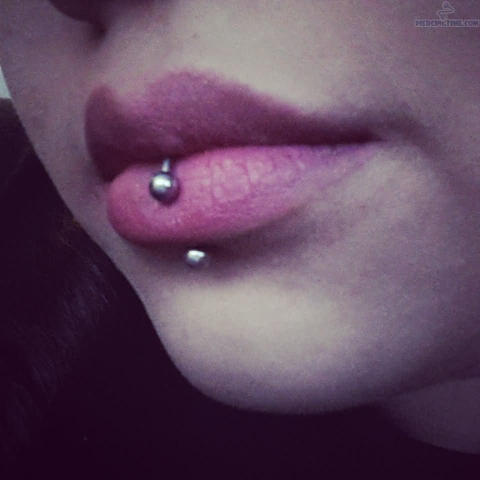 Detalhe de um piercing labret na boca de uma mulher sorridente